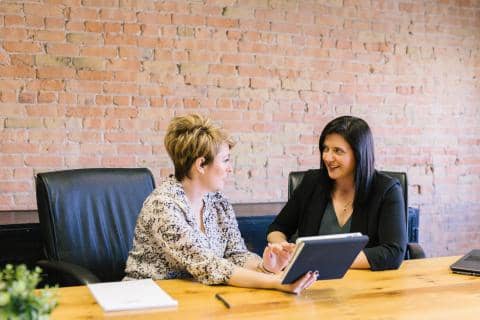 2 femmes discutent au bureau